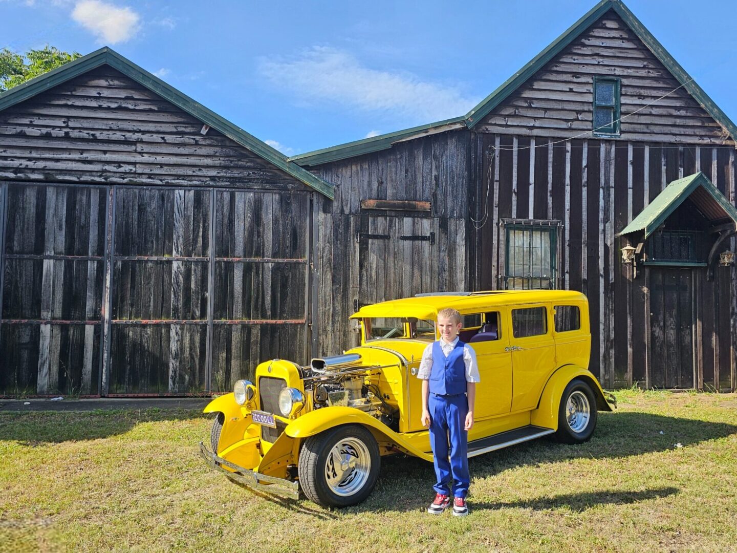 A schoolboy excitedly heading to his formal, riding in our vibrant yellow hot rod – a perfect choice for formal car hire