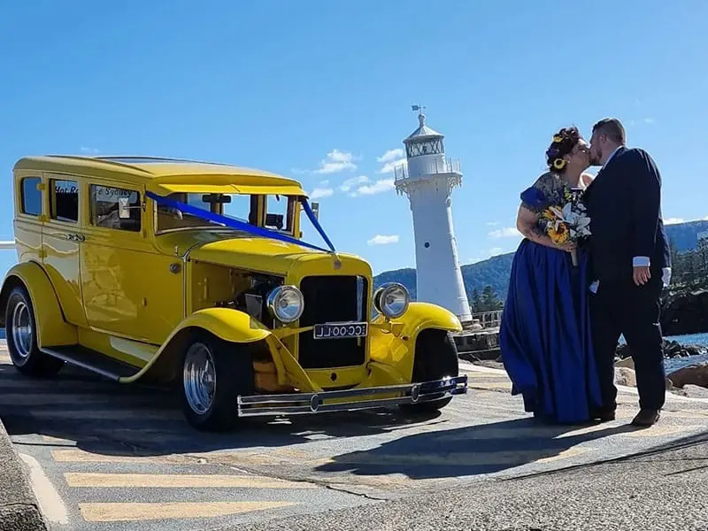 This happy couple seals their wedding day with a kiss, with our yellow hot rod as the perfect backdrop for wedding car hire